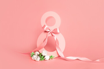 Paper cut eight with ribbon on pink background. Postcard March 8 on a pink background