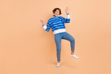 Fototapeta na wymiar Full length photo of impressed cool lady wear blue pullover dancing having fun isolated beige color background