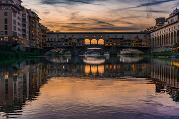 Naklejka premium cruising at dusk on Arno Boat in front of Ponte Vecchio (Florence)