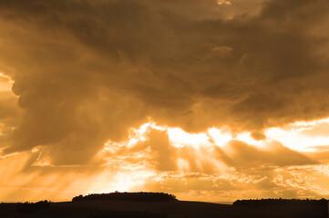 por do sol entre nuvens raios de sol dourados 