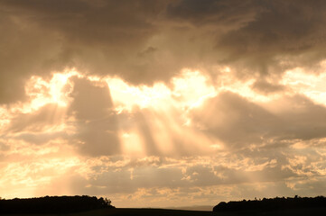 por do sol entre nuvens raios de sol dourados 