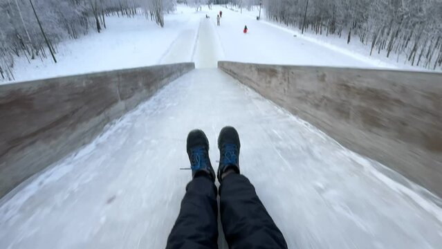 Riding a winter slide Pov video, wide angle. Outdoor winter activities. Selective focus