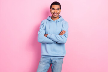 Photo of satisfied glad young man beaming smile crossed arms posing isolated on pink color background