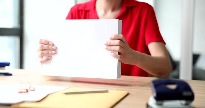 Businesswoman secretary holds many of documents or a4 white blank sheets