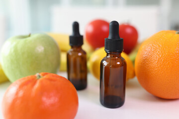 An empty bottle with a dispenser on a table with fruits