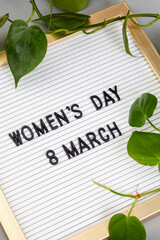 international women’s day, sign saying women’s day 8 March on grey with botanical elements