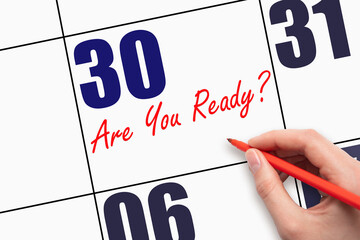 30th day of the month. Hand writing text ARE YOU READY on calendar date.