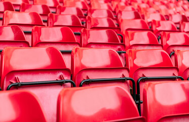 Obraz premium red plastic chair in football, basketball or baseball arena stadium in a row for visitor to visit and enjoy sport match competition for big football match in football stadium