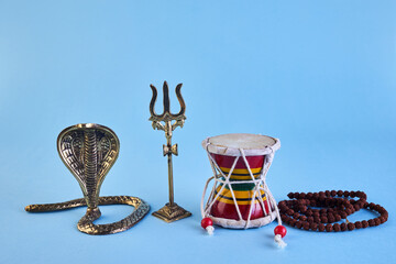 Shivaratri background with Shivas trident, Pellet Drum Damroo musical instrument ans snake . Maha...