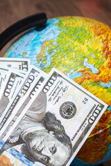 Stack of dollars on background of globe with map