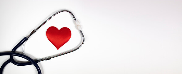 A stethoscope and a red heart on a white background. Banner. Flat lay, top view, copy space.