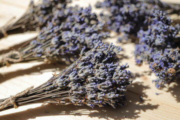 Bundles of dried lavender flowers tied with jute on a wooden table.