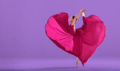 elegant ballerina in pointe shoes dancing in a long red skirt developing in the shape of a heart on a white background