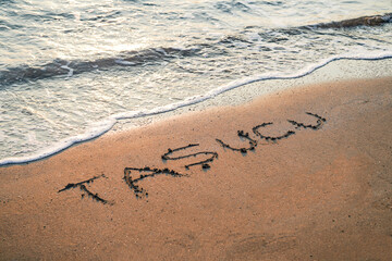 Taşucu beach written on the beach sand near mediterranean sea
