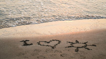 i love sun written on beach sand with emoji, near wave