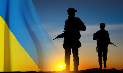 Obraz premium Flag of Ukraine with silhouettes of soldiers against the sunset. Armed forces of Ukraine concept. EPS10 vector