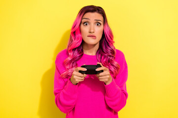 Photo of anxious worried person biting lips hands hold gamepad playing games isolated on yellow color background © deagreez