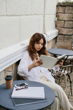 Mockup image magazine book. The girl at the coffee shop table reading magazine.