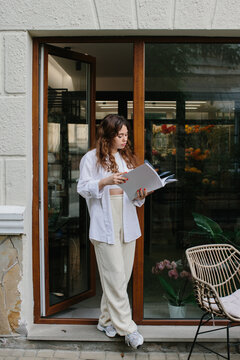 Magazine or book image mockup. A young hipster girl reads a magazine against the background of a cozy coffee shop.