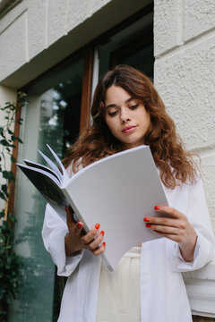 Magazine or book image mockup. A young hipster girl reads a magazine against the background of a cozy coffee shop.