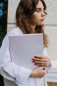 Magazine or book image mockup. A young hipster girl reads a magazine against the background of a cozy coffee shop.