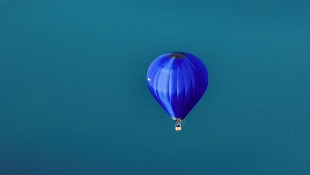 Aerial view of a hot air balloon with turquoise lake behind