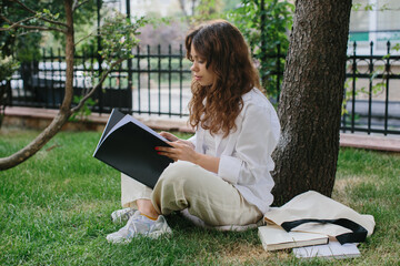 Magazine or book image mockup. The girl relaxes on the lawn in the courtyard of the coffee shop, reads a book.