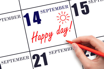 Hand writing the text HAPPY DAY and drawing the sun on the calendar date September 14