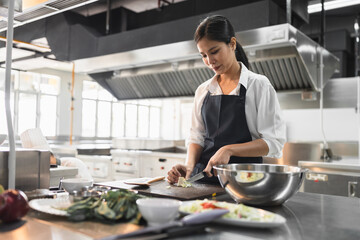 Asia woman assistant chef cooking with and kitchen background