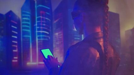 Portrait of cyberpunk girl with a smartphone. Beautiful young woman on the background of city...