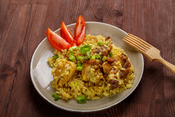 Thai chicken rice on a wooden table next to a wooden fork