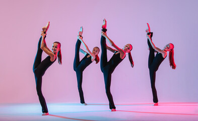 group of five teenagers balrins in black tight-fitting costumes are dancing modern konteporari on a lilac background