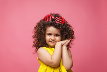 Obraz na płótnie Canvas portrait of a girl in a yellow dress cute attractive cute cheerful cheerful little girl .isolated pink background.