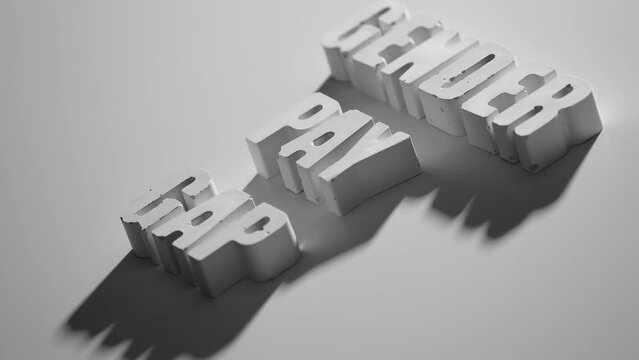 the word GENDER PAY GAP appearing letter by letter on white background with shadows, one of a series of concrete letters from side view
