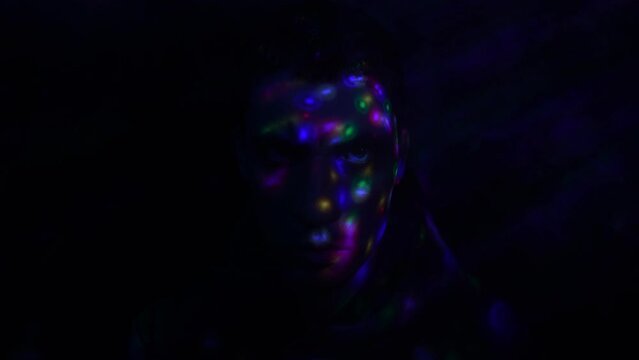 Portrait of a Serious Guy who is Looking at the Camera, in the Dark and Neon Lighting. Slow Motion.