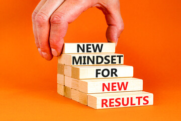 New mindset and results symbol. Concept words New mindset for new results on wooden blocks. Beautiful orange background. Businessman hand. Business new mindset for results concept. Copy space