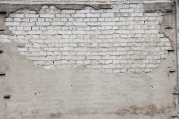 Light brick wall partially plastered.