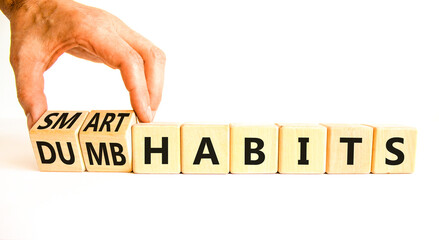 Smart or dumb habits symbol. Concept word Smart habits and Dumb habits on wooden cubes. Beautiful white table white background. Businessman hand. Business smart or dumb habits concept. Copy space.