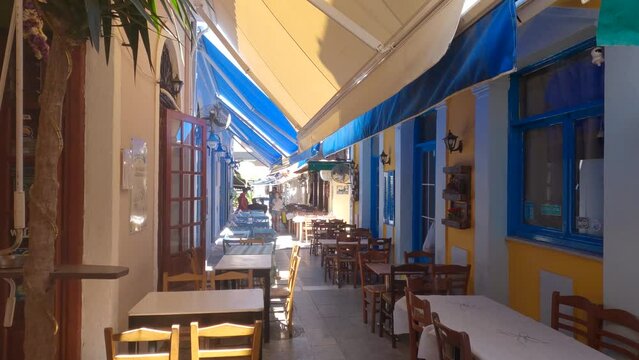 Narrow street with typical restaurants in Preveza, Colorful awnings over esplanade, Greece