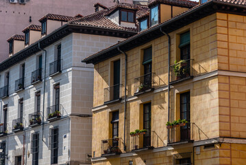 Obraz premium Street in historic center of Madrid, lined with colorful residential buildings.