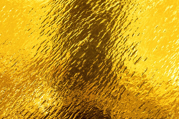Golden background. Luxurious smooth shiny gold texture with fine pattern. yellow background