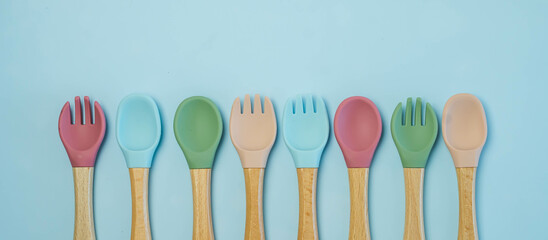 A set of colored silicone forks and spoons with a wooden handle. Baby feeding and nutrition...