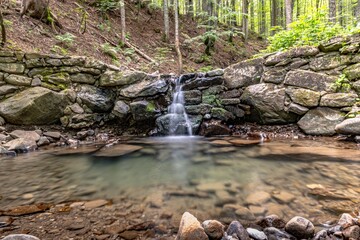 Naklejka na ściany i meble Small stream and waterfall in the woods