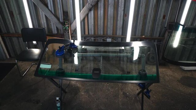 The new windshield is on the table. Installing glass on a car .Slow Motion.