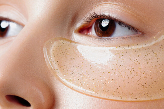 Young beautiful woman with clear gel patches under her eyes in closeup - Powered by Adobe