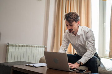 One man adult Caucasian male work on laptop computer from hotel room