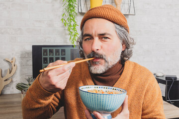 freelance man enjoying oriental food during lunch break at workplace