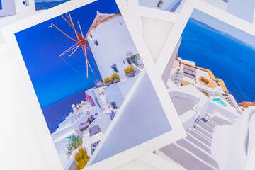 Lot de photos de voyage de différentes vues de Santorin posées sur une table blanche.	