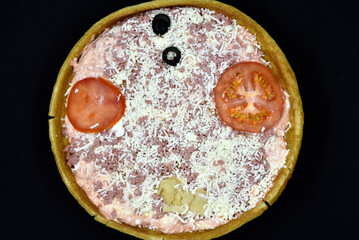 Pizza close-up on a black background. Pizza with meat and tomatoes.