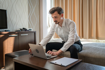 One man adult Caucasian male work on laptop computer from hotel room